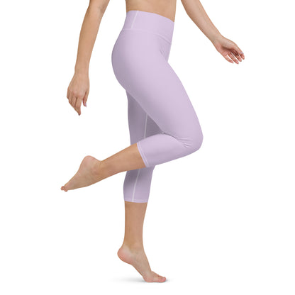 A person wearing lavender yoga capri leggings, with the leggings displaying a high waistband and mid-calf length.